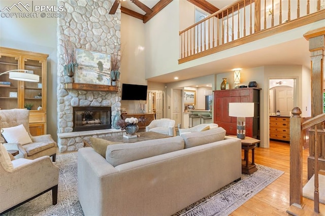 155 Grayson Ct, Colorado Springs, CO 80906 - living room with a towering ceiling, a fireplace, wood finished floors, and beamed ceiling