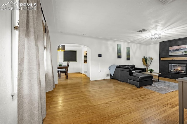 601 N 15th St, Canon City, CO 81212 - living room featuring arched walkways, wood finished floors, and a large fireplace