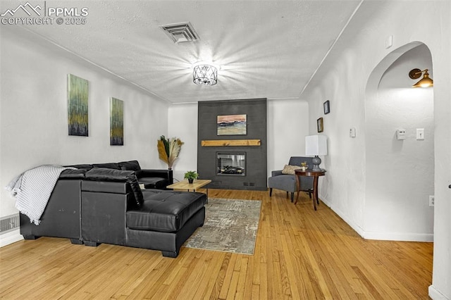 601 N 15th St, Canon City, CO 81212 - living room with arched walkways, wood finished floors, a large fireplace, and a textured ceiling