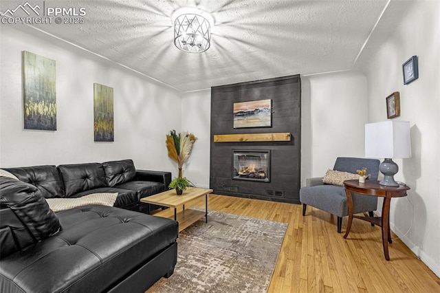 601 N 15th St, Canon City, CO 81212 - living area featuring a fireplace, wood finished floors, and a textured ceiling