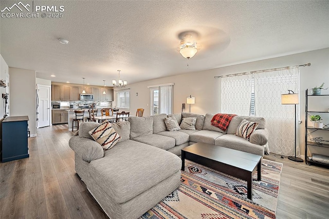 4928 Wolf Moon Dr, Colorado Springs, CO 80911 - living area with a textured ceiling, wood finished floors, a chandelier, a ceiling fan, and recessed lighting