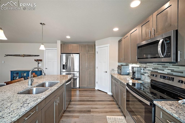 4928 Wolf Moon Dr, Colorado Springs, CO 80911 - kitchen with appliances with stainless steel finishes, light wood-type flooring, tasteful backsplash, light stone countertops, and recessed lighting