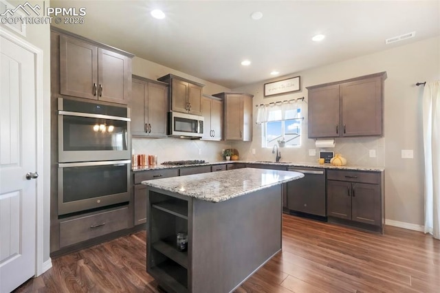 4631 Zircon Dr, Colorado Springs, CO 80938 - kitchen featuring appliances with stainless steel finishes, open shelves, tasteful backsplash, a kitchen island, and dark wood finished floors