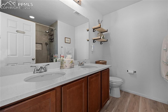 6131 Vickie Ln, Colorado Springs, CO 80923 - full bathroom featuring a tile shower, double vanity, and wood finished floors