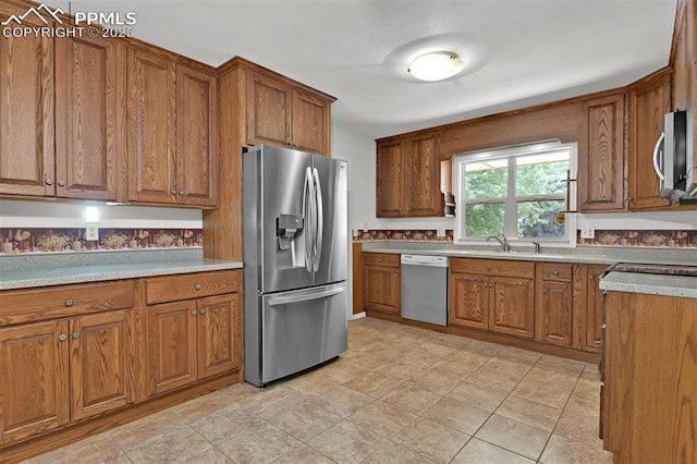 3710 Saddle Rock Rd, Colorado Springs, CO 80918 - kitchen featuring appliances with stainless steel finishes, brown cabinets, and light countertops