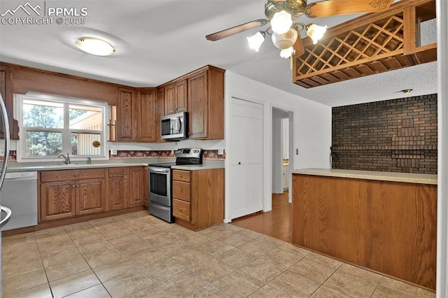 3710 Saddle Rock Rd, Colorado Springs, CO 80918 - kitchen with appliances with stainless steel finishes, brown cabinets, ceiling fan, and a textured ceiling