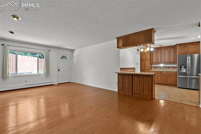 3710 Saddle Rock Rd, Colorado Springs, CO 80918 - kitchen featuring stainless steel fridge, baseboard heating, brown cabinetry, a textured ceiling, and light wood finished floors