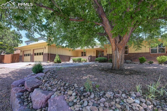 3710 Saddle Rock Rd, Colorado Springs, CO 80918 - single story home with brick siding, a garage, board and batten siding, and concrete driveway
