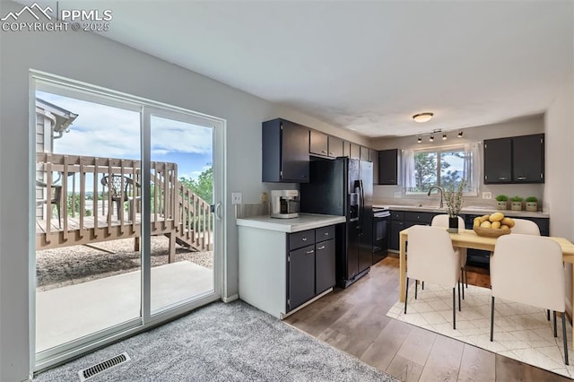 1994 Erin Loop, Colorado Springs, CO 80918 - kitchen with black appliances, light countertops, and light wood-style flooring