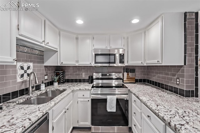 12183 W Chenango Dr, Morrison, CO 80465 - kitchen with appliances with stainless steel finishes, white cabinets, light stone countertops, and recessed lighting