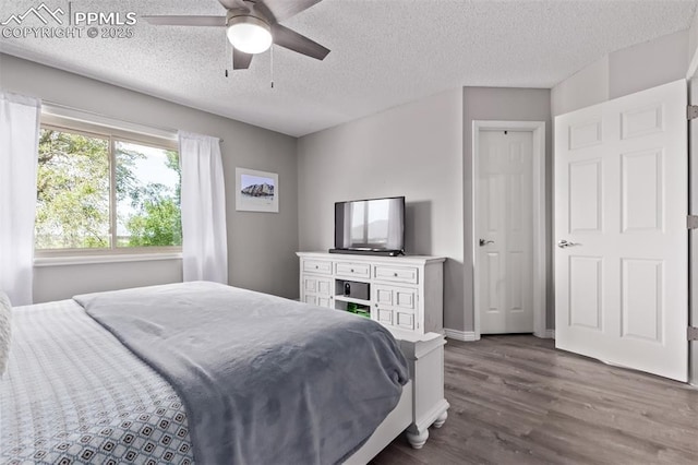 12183 W Chenango Dr, Morrison, CO 80465 - bedroom featuring dark wood-style flooring, a textured ceiling, and a ceiling fan
