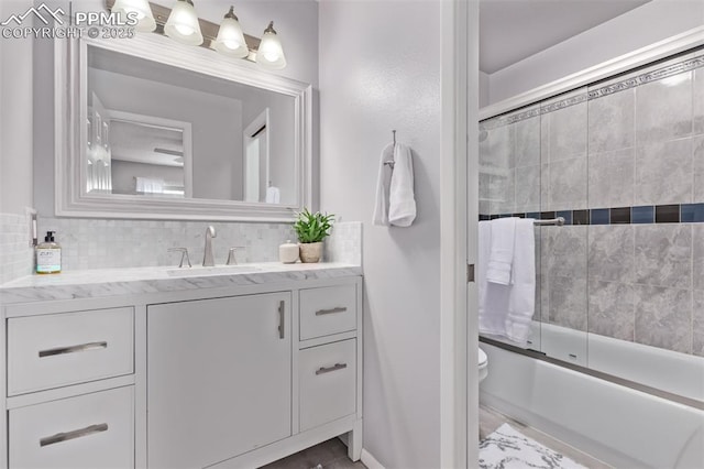 12183 W Chenango Dr, Morrison, CO 80465 - bathroom featuring vanity, combined bath / shower with glass door, and backsplash