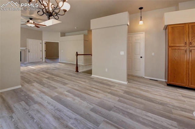 6872 Los Reyes Cir, Colorado Springs, CO 80918 - unfurnished living room featuring ceiling fan, light wood-type flooring, and a chandelier