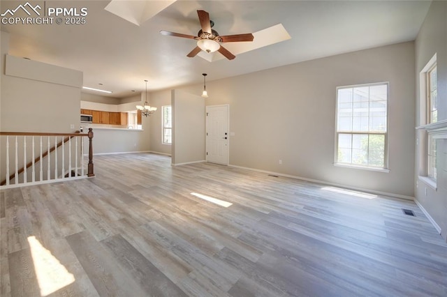 6872 Los Reyes Cir, Colorado Springs, CO 80918 - unfurnished living room with healthy amount of natural light, a chandelier, a ceiling fan, and light wood-type flooring