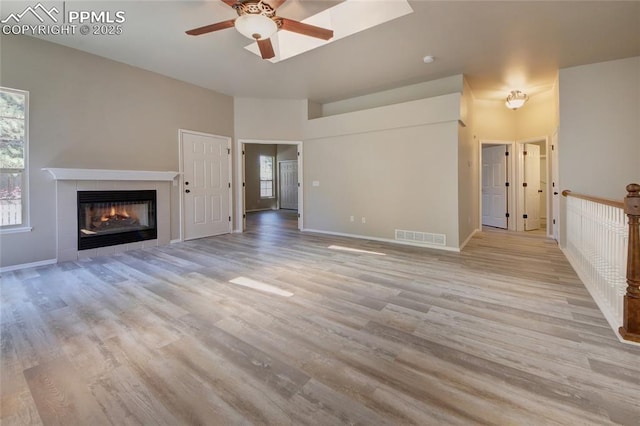 6872 Los Reyes Cir, Colorado Springs, CO 80918 - unfurnished living room with a ceiling fan, light wood finished floors, and a tile fireplace