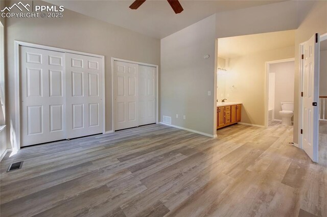 6872 Los Reyes Cir, Colorado Springs, CO 80918 - unfurnished bedroom featuring two closets, light wood finished floors, ensuite bath, and a ceiling fan