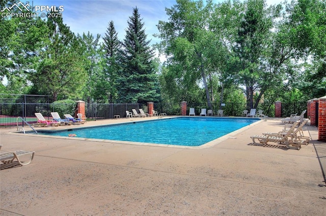 6872 Los Reyes Cir, Colorado Springs, CO 80918 - community pool with a patio area and view of wooded area