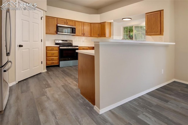 6872 Los Reyes Cir, Colorado Springs, CO 80918 - kitchen with appliances with stainless steel finishes, dark wood-style flooring, light countertops, and brown cabinets