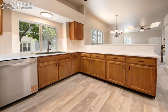 6872 Los Reyes Cir, Colorado Springs, CO 80918 - kitchen with dishwasher, a peninsula, a skylight, and brown cabinetry
