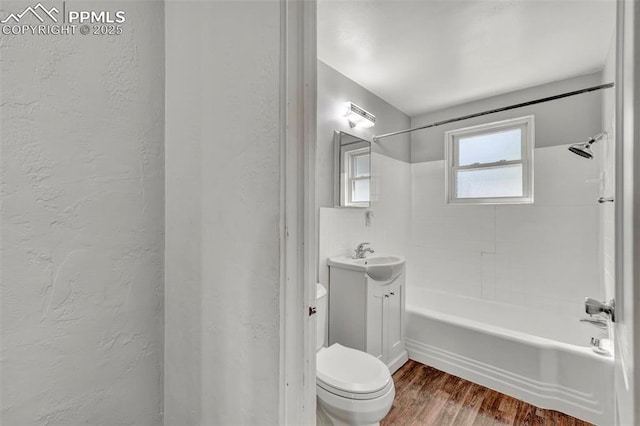 2493 Paseo Rd, Colorado Springs, CO 80907 - full bath featuring vanity, a textured wall, wood finished floors, and tub / shower combination