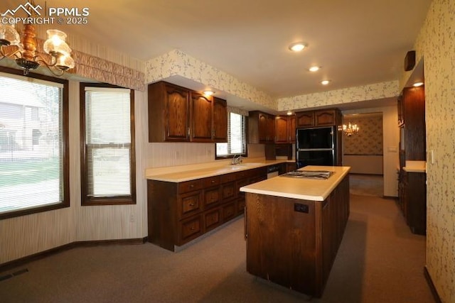 4170 Broadmoor Bluffs Dr, Colorado Springs, CO 80906 - kitchen with a chandelier, wallpapered walls, appliances with stainless steel finishes, light countertops, and a center island