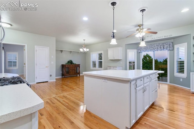 10489 Cedar Breaks Dr, Peyton, CO 80831 - kitchen with a center island, white cabinetry, a chandelier, light wood-type flooring, and light countertops
