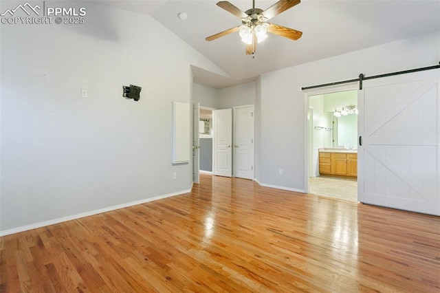 10489 Cedar Breaks Dr, Peyton, CO 80831 - unfurnished bedroom featuring light wood-style floors, a barn door, high vaulted ceiling, connected bathroom, and a ceiling fan