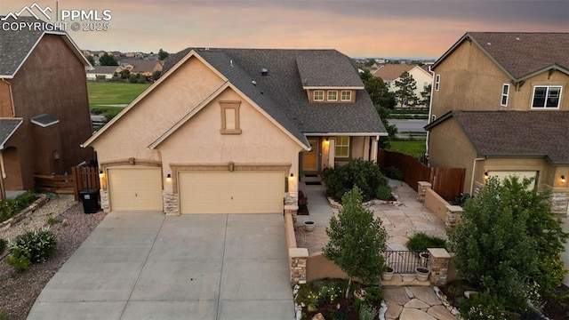 10489 Cedar Breaks Dr, Peyton, CO 80831 - traditional home featuring driveway, stucco siding, a residential view, an attached garage, and stone siding