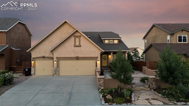10489 Cedar Breaks Dr, Peyton, CO 80831 - view of front of home featuring concrete driveway, stucco siding, a garage, and stone siding
