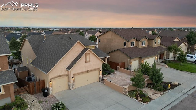 10489 Cedar Breaks Dr, Peyton, CO 80831 - view of front of property featuring concrete driveway, a residential view, a garage, stucco siding, and roof with shingles