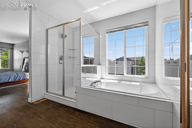 3035 Cascade Falls Pt, Colorado Springs, CO 80922 - bathroom with connected bathroom, a stall shower, a bath, and wood finished floors