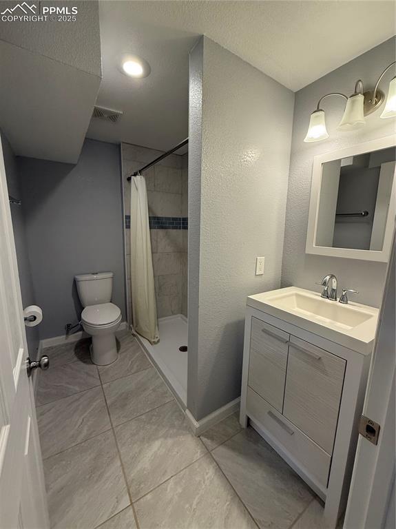 5926 Wisteria Dr, Colorado Springs, CO 80919 - full bathroom featuring vanity and a stall shower