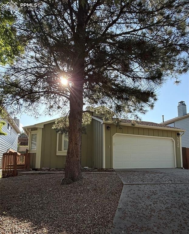 5926 Wisteria Dr, Colorado Springs, CO 80919 - view of front of house with board and batten siding, concrete driveway, and a garage