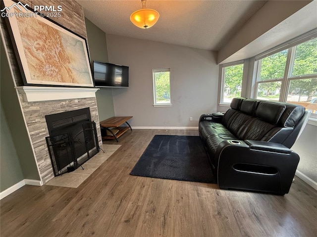 5926 Wisteria Dr, Colorado Springs, CO 80919 - living area with a textured ceiling, wood finished floors, lofted ceiling, and a stone fireplace