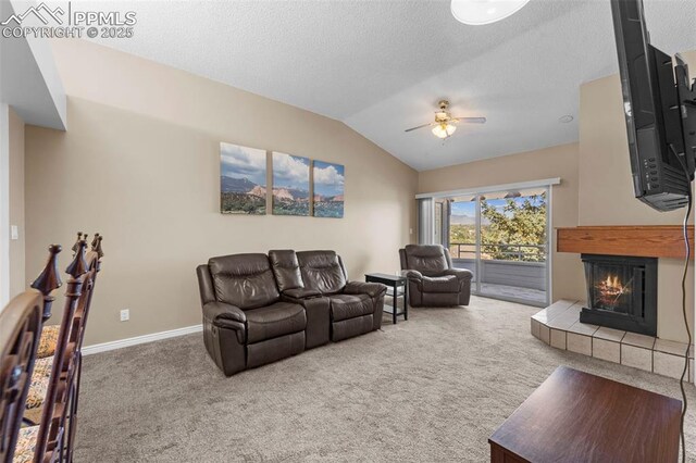 3692 Iguana Dr, Colorado Springs, CO 80910 - carpeted living area with a tiled fireplace, ceiling fan, lofted ceiling, and a textured ceiling