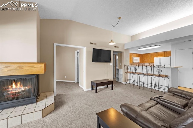 3692 Iguana Dr, Colorado Springs, CO 80910 - living area featuring lofted ceiling, carpet floors, a glass covered fireplace, and a textured ceiling