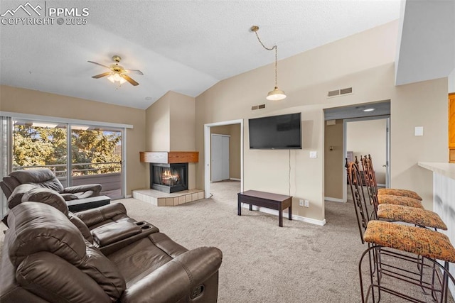 3692 Iguana Dr, Colorado Springs, CO 80910 - living area featuring a tile fireplace, carpet floors, lofted ceiling, ceiling fan, and a textured ceiling