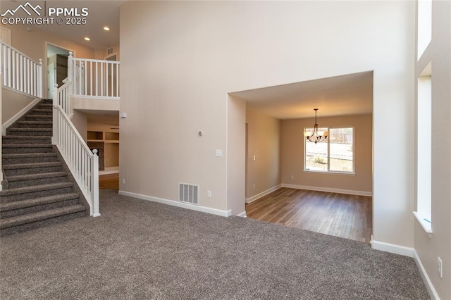 7292 Gardenstone Dr, Colorado Springs, CO 80922 - unfurnished living room with carpet floors, a chandelier, stairway, recessed lighting, and a towering ceiling