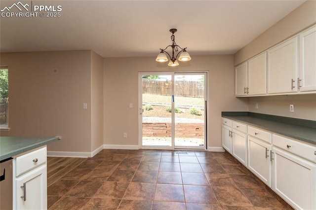 7292 Gardenstone Dr, Colorado Springs, CO 80922 - kitchen featuring dark countertops, a chandelier, white cabinets, and pendant lighting