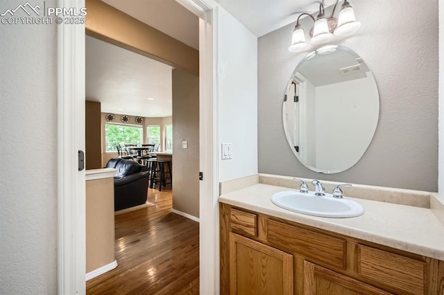 5480 Flag Way, Colorado Springs, CO 80919 - bathroom with wood finished floors, vanity, and a chandelier