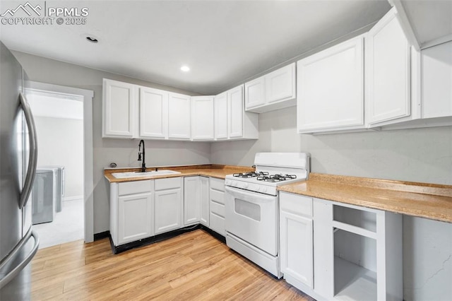 109 S 24th St, Colorado Springs, CO 80904 - kitchen featuring white gas range, freestanding refrigerator, light countertops, light wood-type flooring, and white cabinets