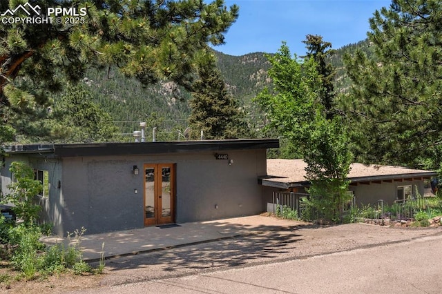 4440 Heizer St, Cascade, CO 80809 - view of front of property featuring french doors, stucco siding, a mountain view, and a forest view