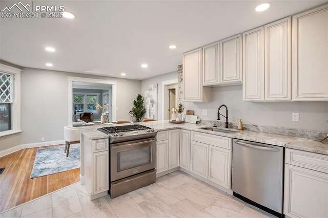 122 E Jefferson St, Colorado Springs, CO 80907 - kitchen with appliances with stainless steel finishes, recessed lighting, light marble finish flooring, a peninsula, and light stone countertops