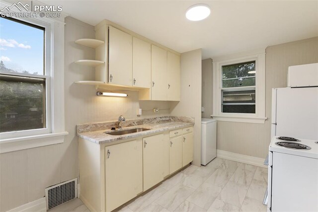 122 E Jefferson St, Colorado Springs, CO 80907 - kitchen featuring white appliances, cream cabinets, light marble finish flooring, open shelves, and washer / dryer