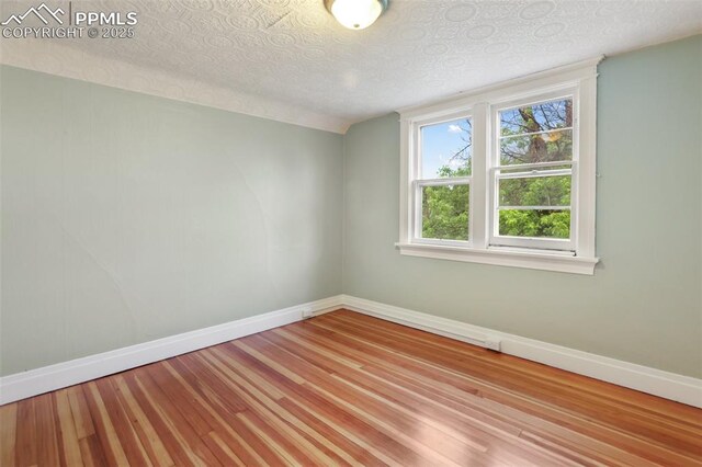 122 E Jefferson St, Colorado Springs, CO 80907 - empty room with wood finished floors and a textured ceiling