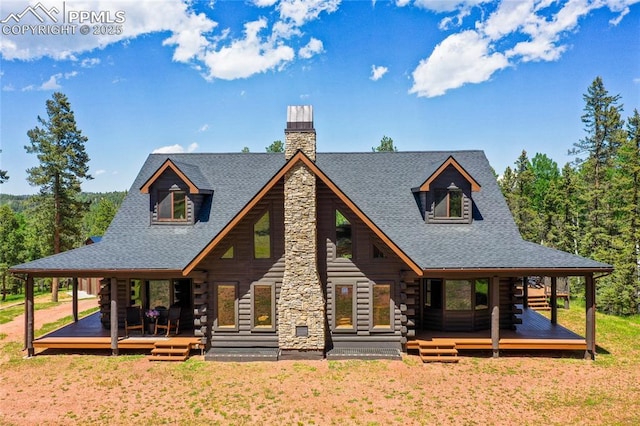 101 Daniwood Grv, Florissant, CO 80816 - log home with log siding, a chimney, a shingled roof, a front yard, and a wooden deck