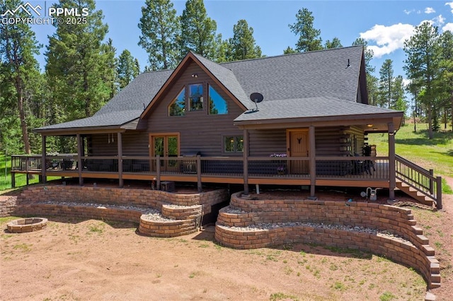 101 Daniwood Grv, Florissant, CO 80816 - view of front facade with an outdoor fire pit, roof with shingles, log siding, and a wooden deck