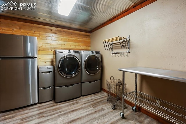 101 Daniwood Grv, Florissant, CO 80816 - laundry room with washing machine and dryer, light wood finished floors, and wooden walls