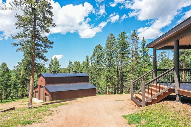 101 Daniwood Grv, Florissant, CO 80816 - view of side of property with a metal roof, an outdoor structure, a gambrel roof, a detached garage, and a chimney