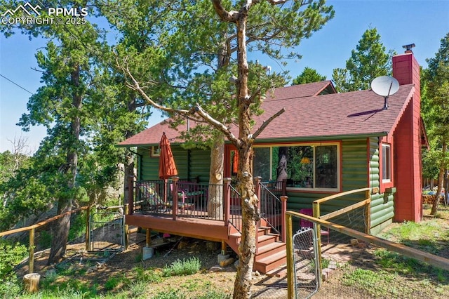 47 Red Cloud Rd, Woodland Park, CO 80863 - view of front of house featuring a shingled roof, log veneer siding, and a chimney